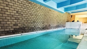 Una piscina interior con suelo y paredes de azulejos.