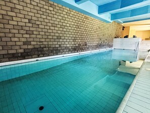 Ein Hallenbad mit gefliestem Boden und Wänden.