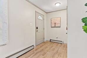 A hallway with a white door, a thermostat, and a framed picture on the wall. - 3BR Home @ Camp Hill Close to Hershey & Harrisburg (Camp Hill)