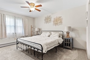 A bedroom with a bed, a ceiling fan, two wall-mounted lamps, and a nightstand. - 3BR Home @ Camp Hill Close to Hershey & Harrisburg (Camp Hill)