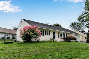 A single-story house with a sloped roof, a front porch, and a small garden with pink flowering bushes. - 3BR Home @ Camp Hill Close to Hershey & Harrisburg (Camp Hill)