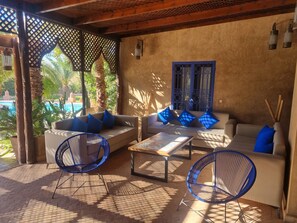 A covered outdoor seating area with a sofa, two chairs, and a table. - Villa with a huge private pool, 15 minutes from Marrakech (Douar Erragueb / Marrakech)