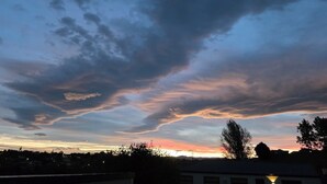 Cielo al tramonto con nuvole su una zona residenziale.
