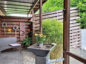 A covered patio area with a wooden bench, a planter with flowers, and a pergola overhead. - Böhmerwald Pur2 by Interhome (Klaffer am Hochficht)