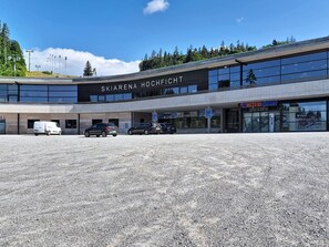 A modern building with a sign reading 'SKIARENA HOCHFICHT'.