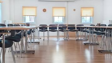 A conference room with a long table, chairs, and large windows with blinds.
