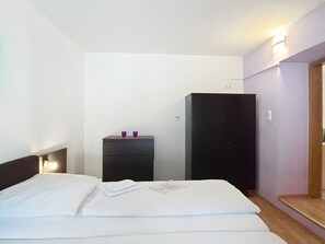 A hotel room with a bed, a dresser, and a wardrobe.