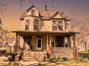 A two-story house with a front porch, a chimney, and a garage.
