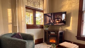 Una sala de estar acogedora con chimenea, televisión y un rincón de estar cómodo.