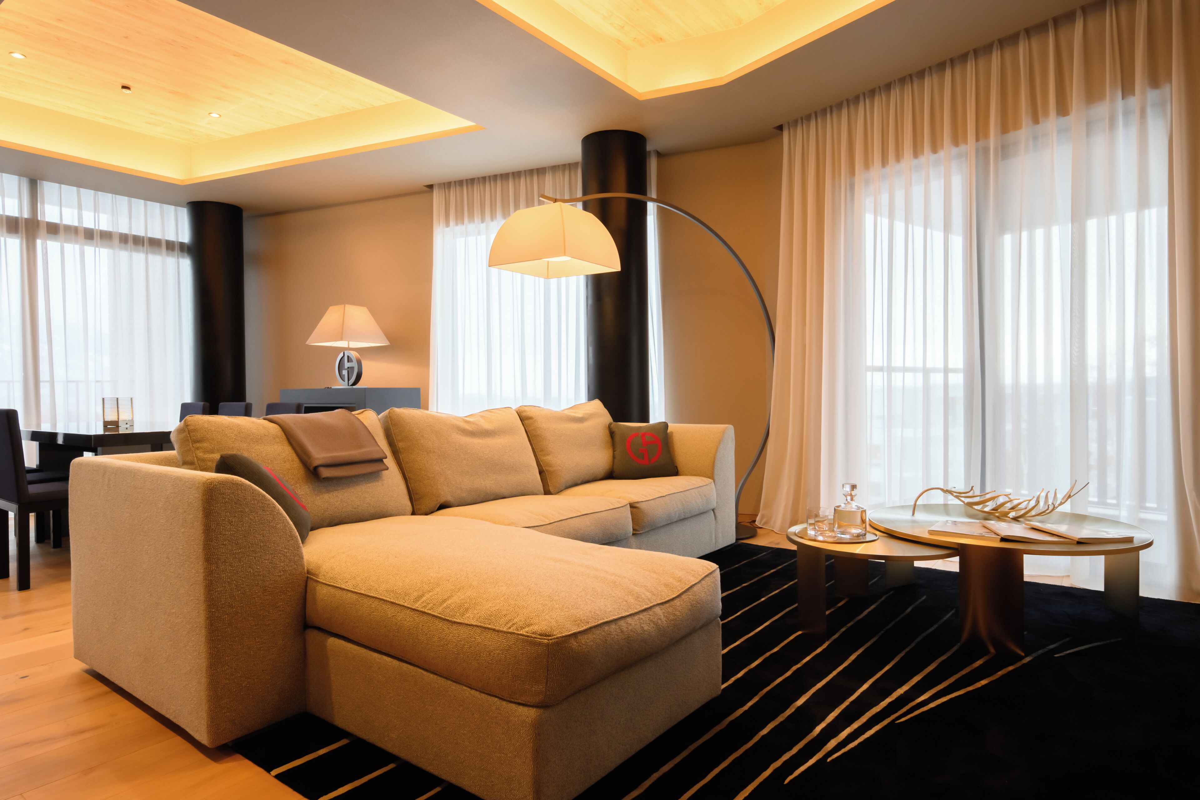 A modern living room with a sectional sofa, a round coffee table, and a floor lamp.