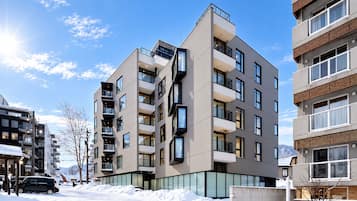 A multi-story residential building with balconies, large windows, and a modern architectural design.