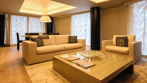 A modern living room with a sofa, armchairs, a coffee table, and a lamp. - HOTELA Niseko Towers  (Kutchan)