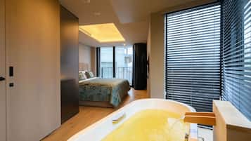 Una camera da letto moderna con un letto grande, una vasca e un balcone.