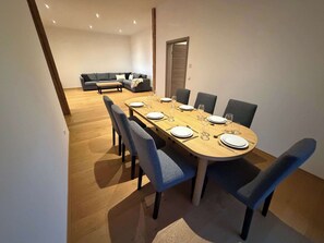 A dining area with a wooden table set for six, surrounded by six chairs. - Neumuehle - Historisch und modern - Wohnung 1 (Altenkunstadt)