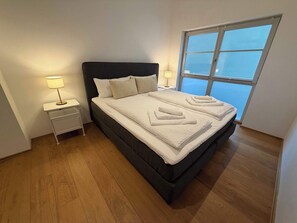 A bedroom with a bed, bedside tables, and a window. - Neumuehle - Historisch und modern - Wohnung 1 (Altenkunstadt)