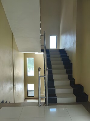 Una escalera con barandilla metálica que sube a un piso superior.