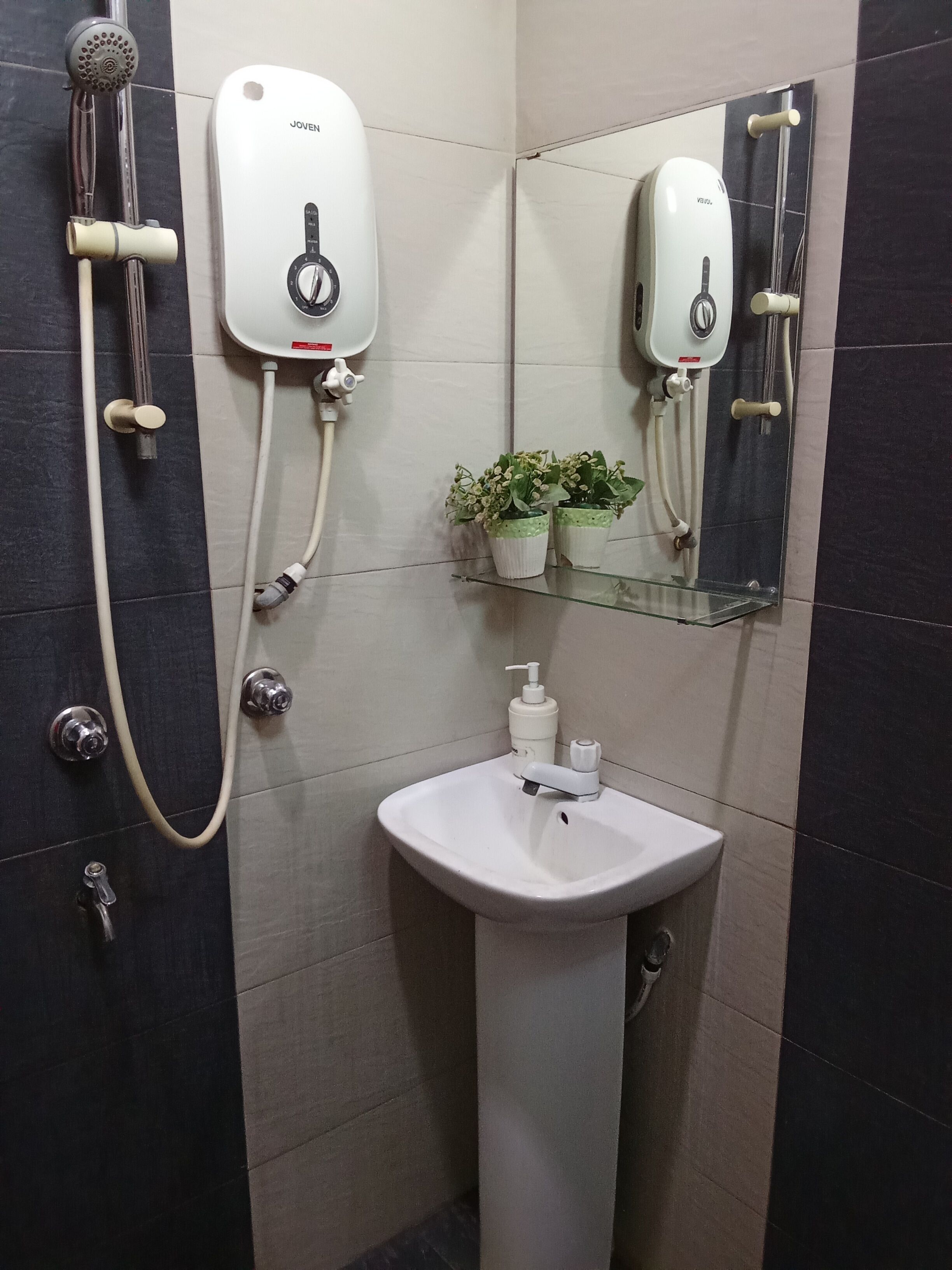 A bathroom with a shower, a sink, and a mirror.
