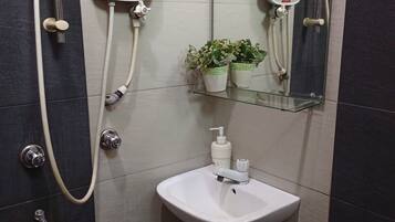 A bathroom with a shower, a sink, and a mirror.