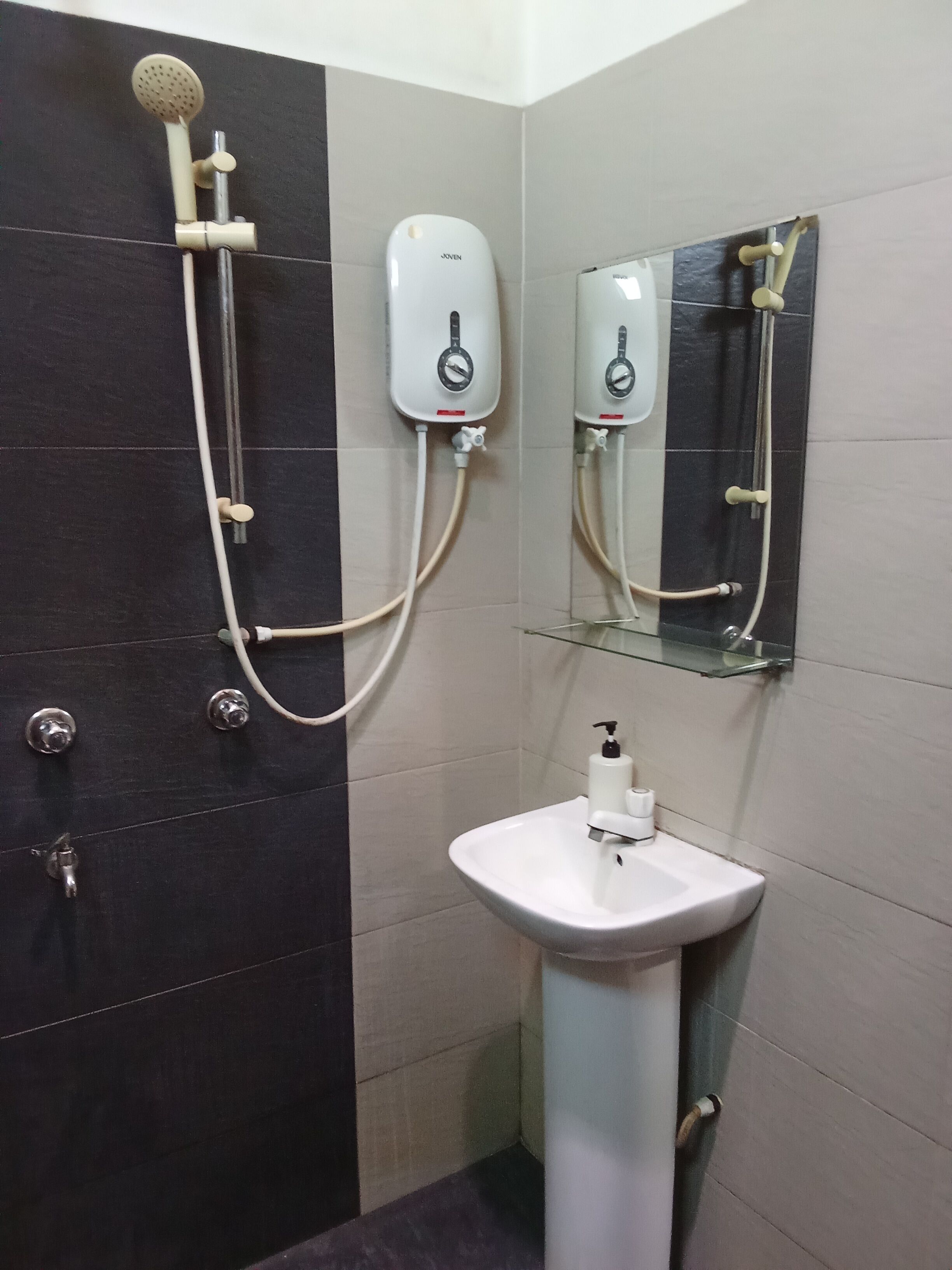 Une salle de bain avec une douche, un lavabo et un miroir.
