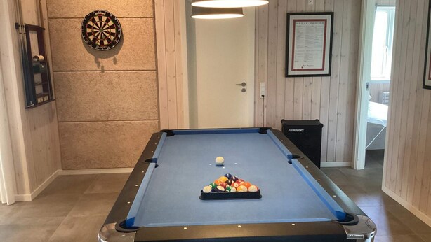 A pool table with balls, a dartboard, and a framed certificate on the wall. - 4 Star Holiday Home in Vaeggerlose (Vaeggerlose)