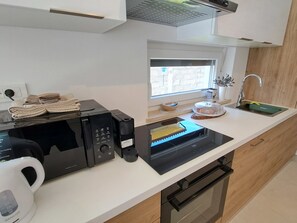 A modern kitchen with a built-in microwave, oven, and a coffee maker. - Vacation home Duplex by Interhome (Pula/Puntižela)