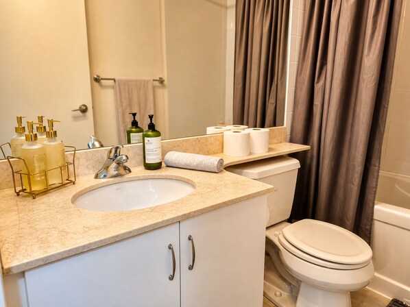 A bathroom with a sink, toilet, and shower curtain.