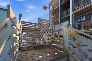 A wooden staircase leading to a building with multiple balconies. - Water's Edge | Coastal Condo with Ocean Views (North Topsail Beach)