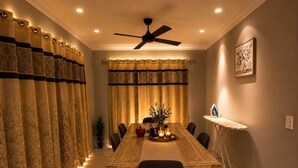 A dining area with a long table, chairs, a ceiling fan, and curtains. - Private Duplex - Pimpama / Gold Coast (Pimpama)