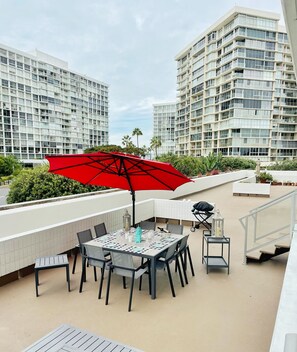 A rooftop patio with a table set for dining, surrounded by modern buildings. - CORONADO SHORES 
Las Flores Tower. Beautiful 2 bed/2 bath
Short-Term & Long-Term (Coronado)