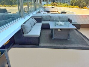 A rooftop terrace with a sectional sofa, a small table, and a glass railing. - CORONADO SHORES 
Las Flores Tower. Beautiful 2 bed/2 bath
Short-Term & Long-Term (Coronado)
