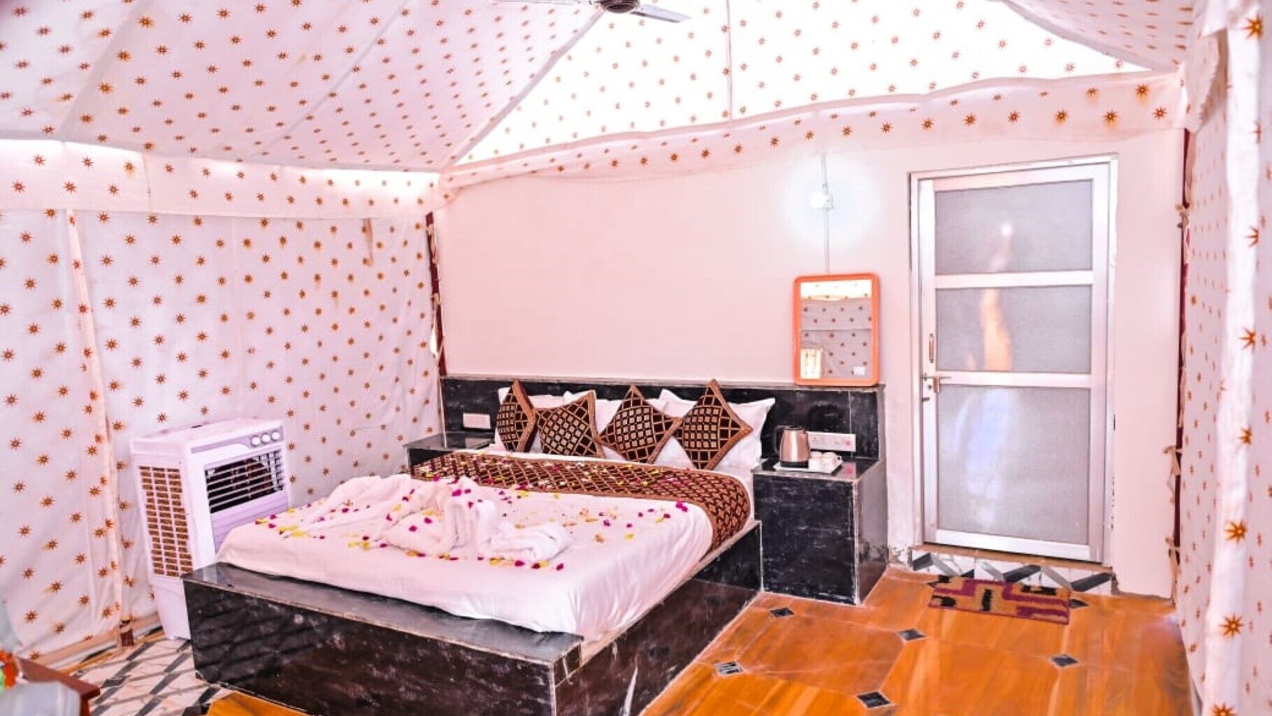 A room with a bed, a nightstand, a mirror, and a window.