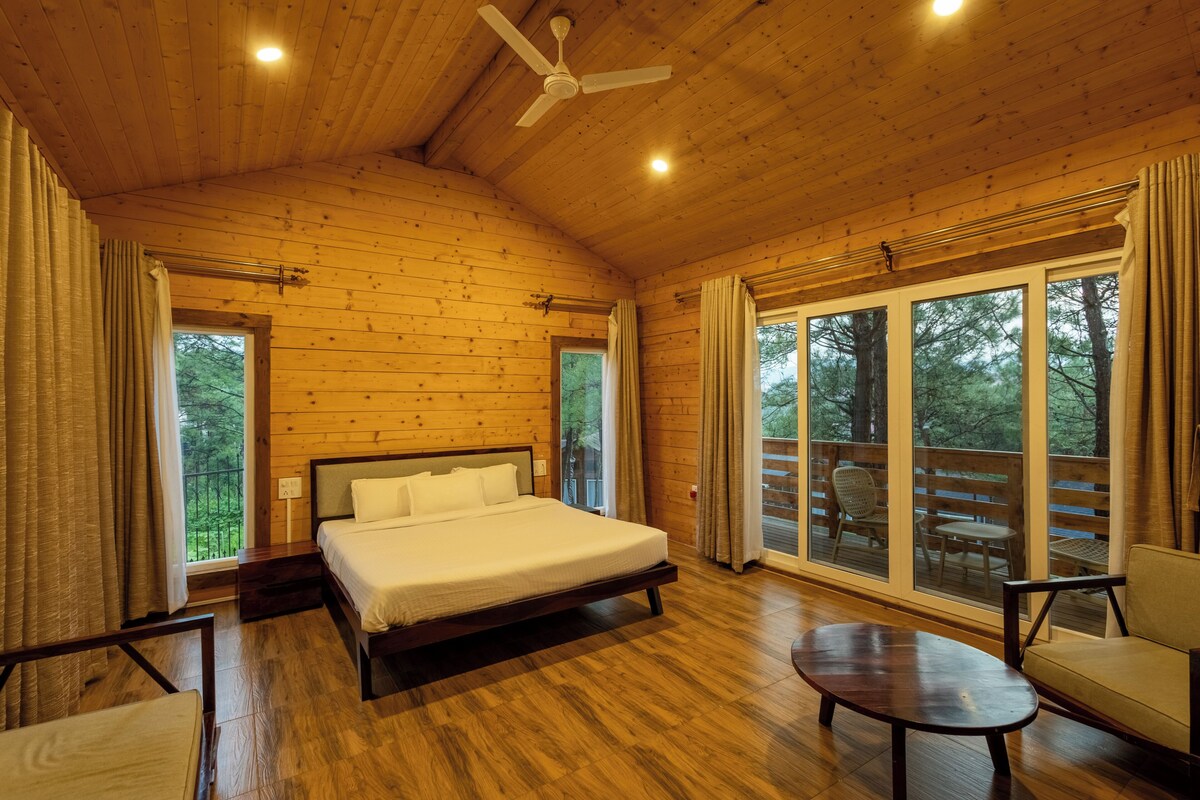 A spacious bedroom with a large bed, a ceiling fan, and a view of the outdoors through a sliding glass door.