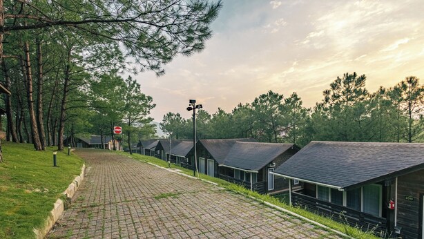 A row of cabins with sloped roofs, a paved pathway, and a 'Street Zone' sign. - Leikyard Resort Shillong (Shillong)