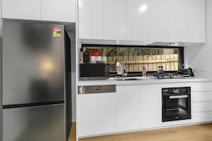 A modern kitchen with stainless steel appliances, a dishwasher, and a built-in oven. - Walk to MCG & Tennis | 3BR | 2 Bath | Cremorne (Cremorne)