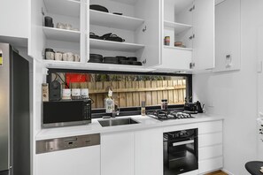 Una cocina moderna con armarios blancos, estufa integrada y lavavajillas.