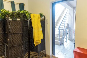 A room with a black woven partition, a yellow cloth, and a staircase leading to an upper floor. - Peaceful 2-bedroom apartment with AC in vibrant Lekki (Lekki)