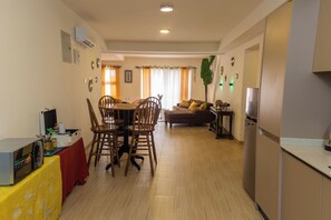 A dining area with a wooden table and chairs, a kitchen with a refrigerator, and a living area with a sofa and a coffee table. - Peaceful 2-bedroom apartment with AC in vibrant Lekki (Lekki)