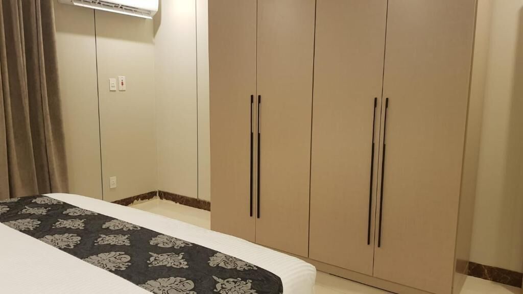 A bedroom with a bed, a wardrobe, and a curtain.