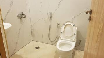 Un baño con inodoro, ducha y lavamanos.