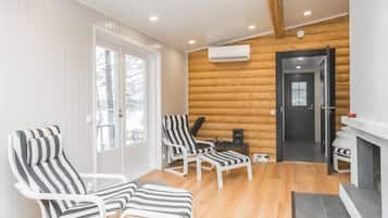 Une pièce comprenant deux fauteuils à rayures, une petite table et une porte donnant sur une autre pièce.