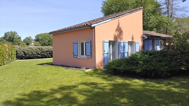 A small house with a tiled roof, a single window with shutters, and a well-maintained lawn. - Maison avec piscine sur un golf (Fiac)