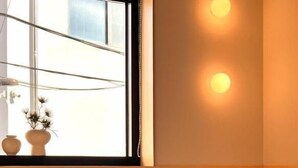 Una camera d'albergo con un letto, una finestra vista e un lampadario a parete.
