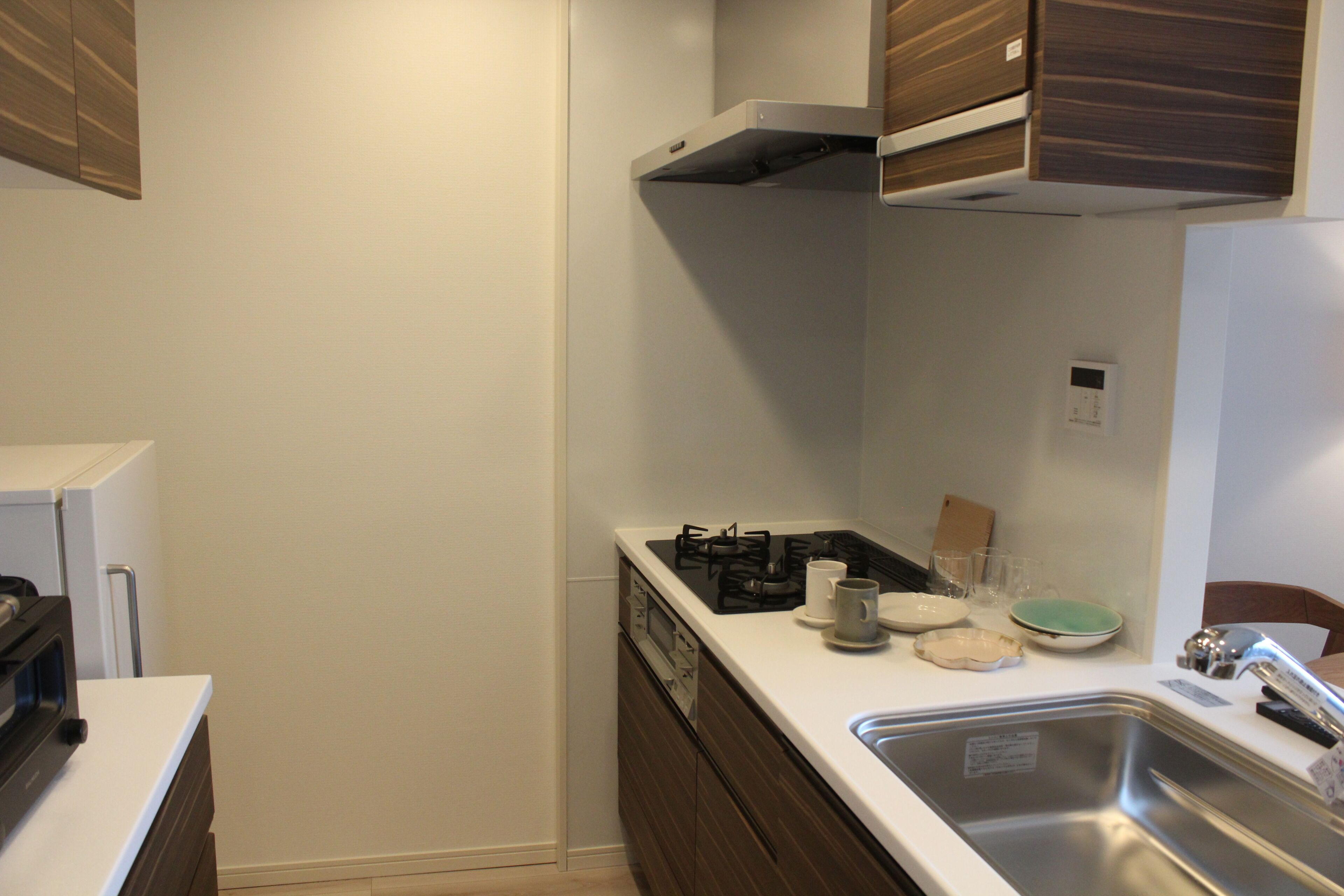 Una cocina compacta con estufa, lavamanos y armarios.