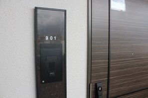 Ein an der Wand befestigtes Gegensprechanlage mit der Nummer 901.