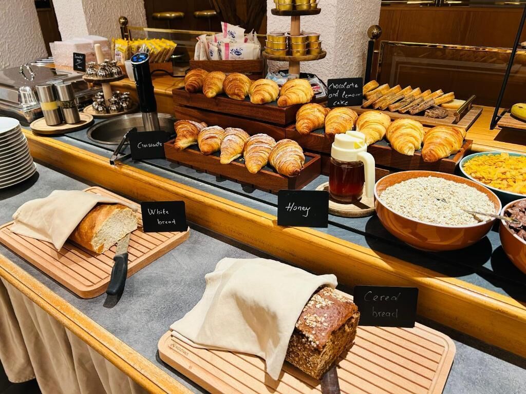 A buffet with labeled bread options, including white, honey, and cereal bread.