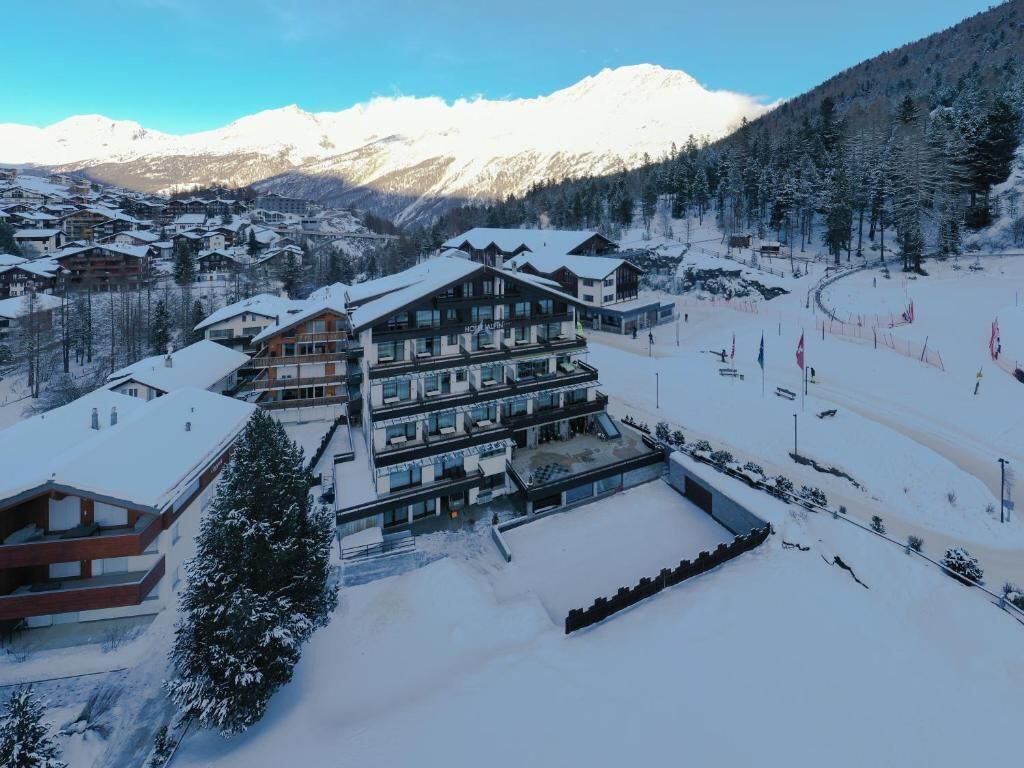 A multi-story building with a ski slope in the background.