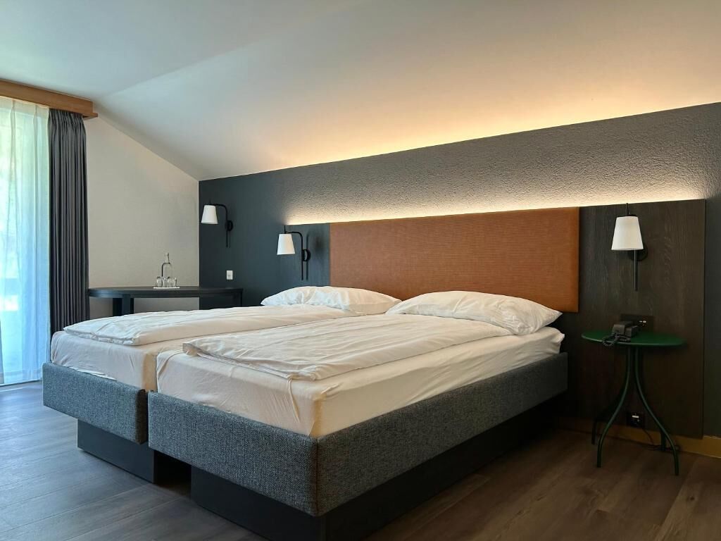 Ein Doppelbett mit Kopfteil, Nachttischen und Lampen.
