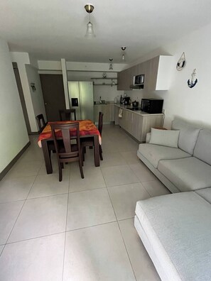 A compact living space with a dining area, kitchenette, and a sofa. - Great Apartment Costa Rica, Punta Esmeralda (Tárcoles)