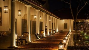 A hotel corridor with columns, chairs, and lanterns. - Rekawa Wellness Resort  (Netolpitiya)