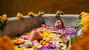 A person lying on a bed surrounded by flowers. - Rekawa Wellness Resort  (Netolpitiya)